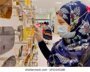 Melaka, Malaysia February 12,2021: Young Muslim Asean Women Shopping During Pandemic Covid19 Wearing Face Mask And Plastic Glove For Protection From Virus