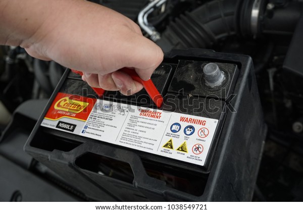 Melaka, Malaysia - March 3, 2018: Process of\
changing the car battery using\
tools.
