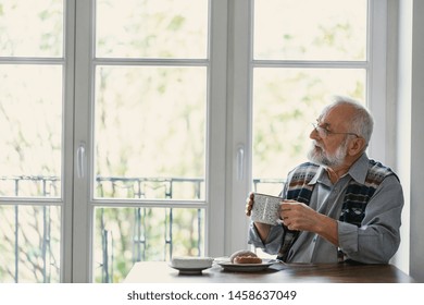 Melancholic Grandfather Eating Breakfast At The Table All Alone