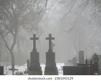Melancholic mood in a foggy old Christian cemetery. Winter day. 