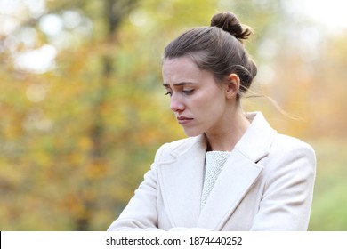 Melancholic Sad Woman Looking Down Walking Alone In A Park In Winter