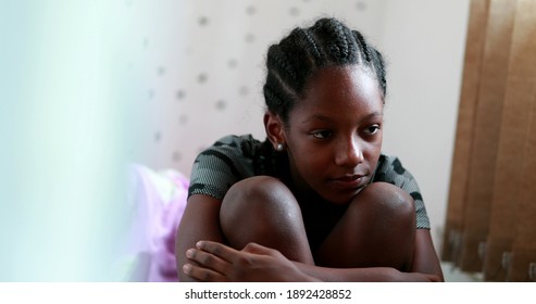 Melancholical sad girl. Black teenager African young suffering from depression