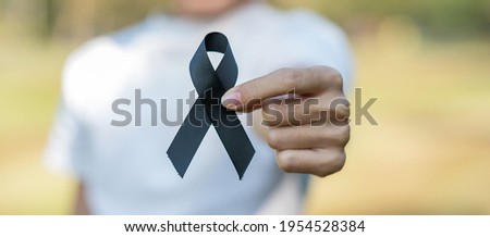 Melanoma and skin cancer, Vaccine injury awareness month and rest in peace concepts. Woman holding black Ribbon