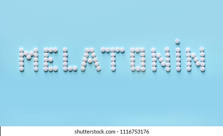 Melatonin, The Word Is Laid Out On A Blue Background Of Tablets. Tablets, Hormone And Excipients To Improve Sleep.