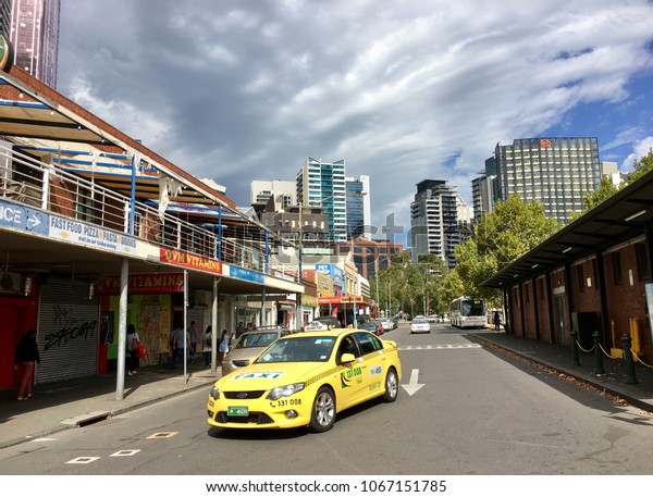 Melbourne,\
Australia: April 12, 2018: A yellow taxi drives through a back\
street near Melbourne’s Victoria\
Market.