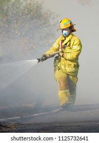 Melbourne, Australia - April 13, 2018: Fire Fighter With A Hose At A Bush Fire In An Suburban Area Of Knox City In Melbourne East.