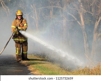 Melbourne, Australia - April 13, 2018: Fire Fighter With A Hose At A Bush Fire In An Suburban Area Of Knox City In Melbourne East.