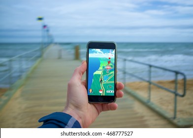 Melbourne, Australia - August 12, 2016: Male Hand Holding IPhone 6 With Pokemon Go Game On A Pier.