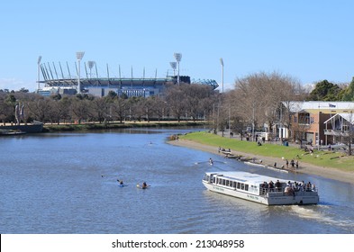 MELBOURNE AUSTRALIA - AUGUST 23, 2014: Sightseeing boat cruises in Yarra river, MCG in background - Melbourne Cricket Ground also know as MCG hosts AFL Ground final game. 