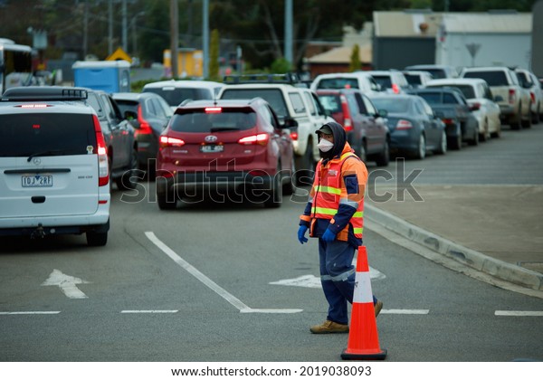 MELBOURNE,\
AUSTRALIA - Jul 19, 2021: The drivers in cars wait in long queues\
at a Bacchus Marsh pop-up drive through coronavirus testing site\
during Victoria\'s fifth covid-19 lockdown\
