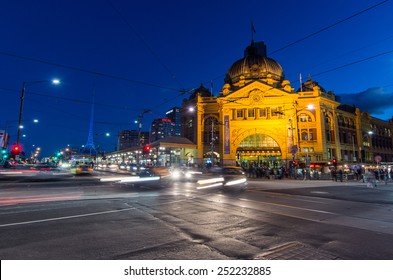 MELBOURNE, AUSTRALIA - June 8, 2014: Flinders Street Station Is The Main Rail Hub For Suburban Commuter Trains. Shown Here At Dusk With Cars And Pedestrians Blurred By Long Exposure.