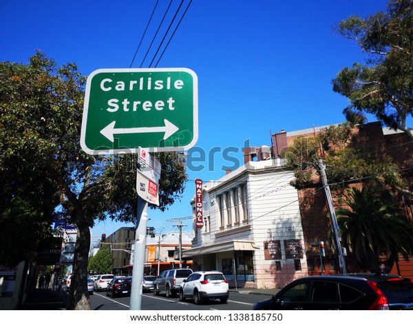 Melbourne,\
Australia: March 14, 2019: Street sign for Carlisle Street in St\
Kilda. A typical Melbourne suburb with traffic old style buildings\
and a busy residential environment.\
