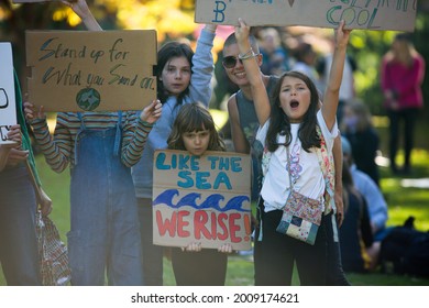 MELBOURNE, AUSTRALIA - May 21, 2021: Primary School Activists With Their Parents At The Climate Change Protest In Melbourne  Kids Holding Global Warming Signs March At A Rally For Climate