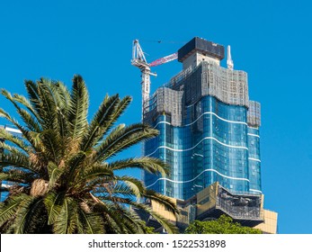 Melbourne, Australia - October 2019: Australia 108 Building Under Construction, It Will Become The Tallest Building In Melbourne's Central Business District. Clear Blue Sky, A Crane And A Palm Tree.