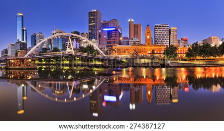 Melbourne CBD cityline at sunrise reflecting bright city illumination lights in still yarra river waters