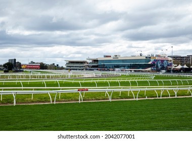 Melbourne, Victoria, Australia - 09.15.2021: The Grandstand, Barriers, Billboards And Lush Green Grass At Caulfield Racecourse, A Famous Horse Racing Track In Melbourne. Home Of The Caulfield Cup.