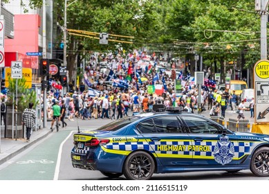 Melbourne, Victoria, Australia, January 15, 2022: A Victoria Police Highway Patrol Car Blocks The Road During An Anti Vaccination March Through The City.