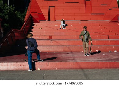 Melbourne, Victoria, Australia - July 8 2020: 2 Teens Kiss Each Other On What Would Usually Be A Busy Public Space. 2 Kids Skate In The Foreground. This Is The Day Before The Second Lockdown.