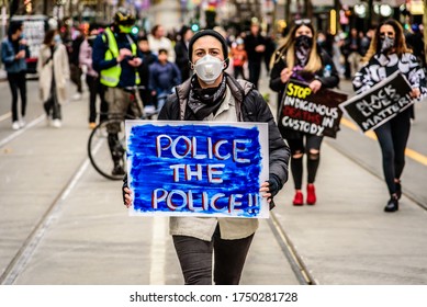 Melbourne, Victoria, Australia, June 6th, 2020: An unidentified woman is carrying a homemade placard saying "police the police" to a Black Lives Matter street protest