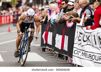MELBOURNE, VICTORIA, AUSTRALIA - MARCH 23, 2014 - Travis Atkins of Australia passes spectators on the 180km Ironman bike leg on March 23, 2014.