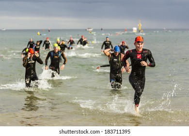 MELBOURNE, VICTORIA, AUSTRALIA - MARCH 23, 2014 - Unidentified male Ironman athletes exit the water after a 3.8km swim on March 23, 2014.