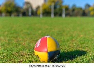 Melbourne, Victoria, Australia, May 20, 2017: An AFL Football Sits On The Grass With Goal Posts In The Distance At JJ Holland Park