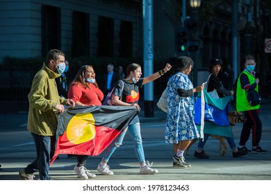 Melbourne, Victoria, Australia, May 21 2021: Indigenous Australians Holding The Aboriginal Flag On The City Streets At The Student Climate Protest. First Nations People Wearing Masks Protesting.