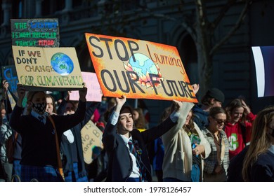 Melbourne, Victoria, Australia, May 21 2021: Group Of Student Protesters Striking For Climate Change Action Holding Signs And Banners And Wearing Covid19 Masks And School Uniforms.