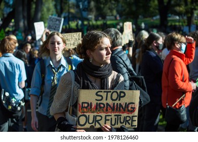 Melbourne, Victoria, Australia, May 21 2021: Group Of Student Protesters Striking For Climate Change Action Holding Signs And Banners And Wearing Covid19 Masks And School Uniforms.