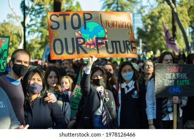 Melbourne, Victoria, Australia, May 21 2021: group of student protesters striking for climate change action holding signs and banners and wearing covid19 masks and school uniforms.