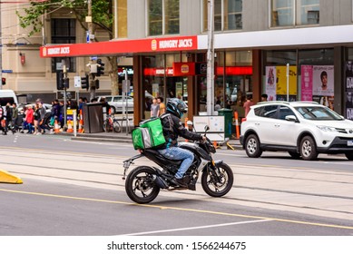 Melbourne, Victoria, Australia, November 11th, 2019: A Menulog Food Delivery Motorcycle Driver Is On His Way To Deliver Food In The City Of Melbourne