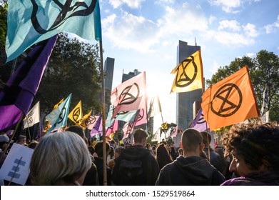 Melbourne, Victoria, Australia: October-11-2019: Protestors of Extinction Rebellion engaging in peaceful "Disco Disruption" protest - Afternoon sun shines through Extinction Rebellion flags
