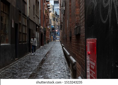 Melbourne, Victoria / Australia - Sept 23 2019: Man Walking Through An Old Cobble Stone Alley Way In Melbourne On A Rainy Day