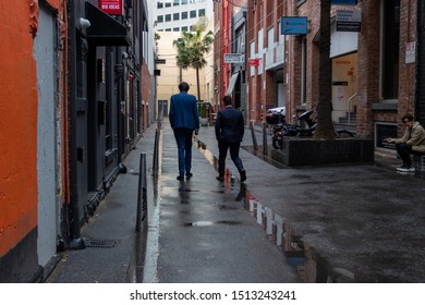 Melbourne, Victoria / Australia - Sept 23 2019: Pair Of Businessmen Walking Down To A Small Cafe In An Alley Way  On A Rainy Day In Melbourne