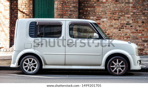 Melbourne, Victoria / Australia - September 2019:\
Nissan Cube parked in the streets around Central Business District,\
brick wall background. Japanese model car.  Mini Multi-Purpose\
Vehicle (MPV).