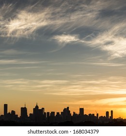 Melbourne's CBD district is silhouetted against a sunset.