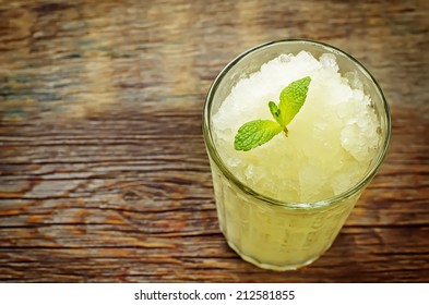 Melon Granita On Dark Wood Background. Tinting. Selective Focus On Mint