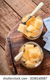 Melon. Pieces Of Fresh Melon For Making Fruit Dessert In Glass On An Old Wooden Background. Mock Up. Top View.