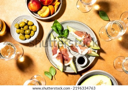 Melon with prosciutto served with wine for summer mediterranean wine tasting