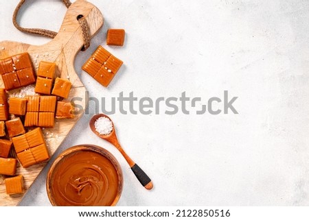 Melt caramel sauce in bowl awith toffee candies, top view