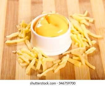 Melted Cheddar Cheese Dip On A Wooden Board