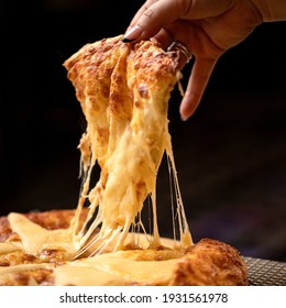 Melted cheese stretches on slice of hot pizza. Woman takes a slice of pizza. Delicious Pizza. Traditional italian food, close up shot. Nutrition dinner or lunch.
