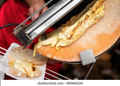 Melted Raclette Cheese Flows On A Bread, Food Culture In Switzerland And France