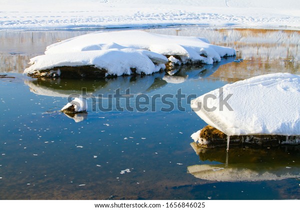 Melted snow\
covered frozen lake river in\
spring