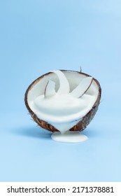Melted soft coconut ice cream, coconut chips, blue background. Coco milk. Coco taste