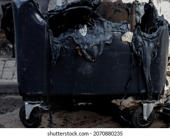 Melted Trash Can From Fire. Burned Trash In Waste Container In The City 