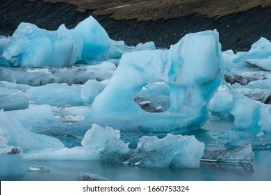 Melting blue ice formation with heart shape hole in Jokulsarlon glacier lagoon, Iceland - Powered by Shutterstock
