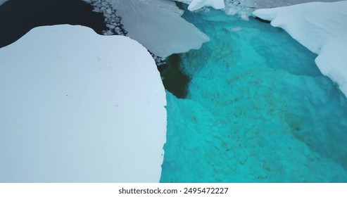 Melting blue water lake in Antarctic glacier aerial view. Snow covered iceberg with melted turquoise hole inside. Polar climate change. Arctic winter landscape, global warming problem. Drone flight - Powered by Shutterstock