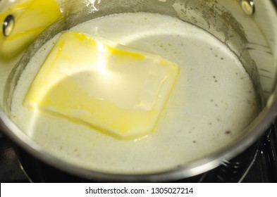Se derrite mantequilla o margarina en la sartén de la estufa. Proceso de concepto de cocina. Cocina vista de primer plano. 