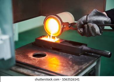 Melting gold. Molted metal pouring into bar form